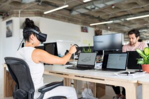 femme avec casque de réalité virtuelle dans un bureau